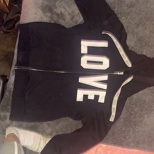 Black hoodie with the word love written in white and it has a zipper that works